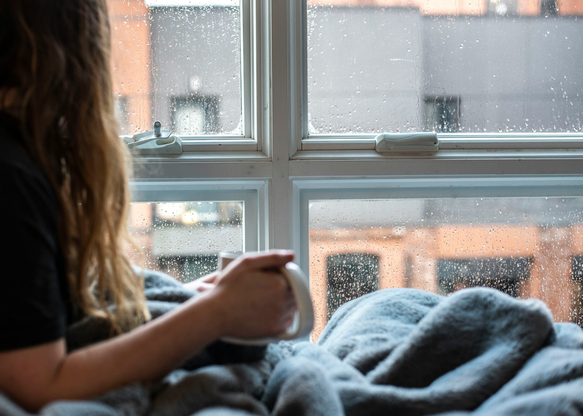 aircon not heating Gold Coast — a homeowner wrapped in a blanket on a cool winter morning, wondering why the house feels cold
