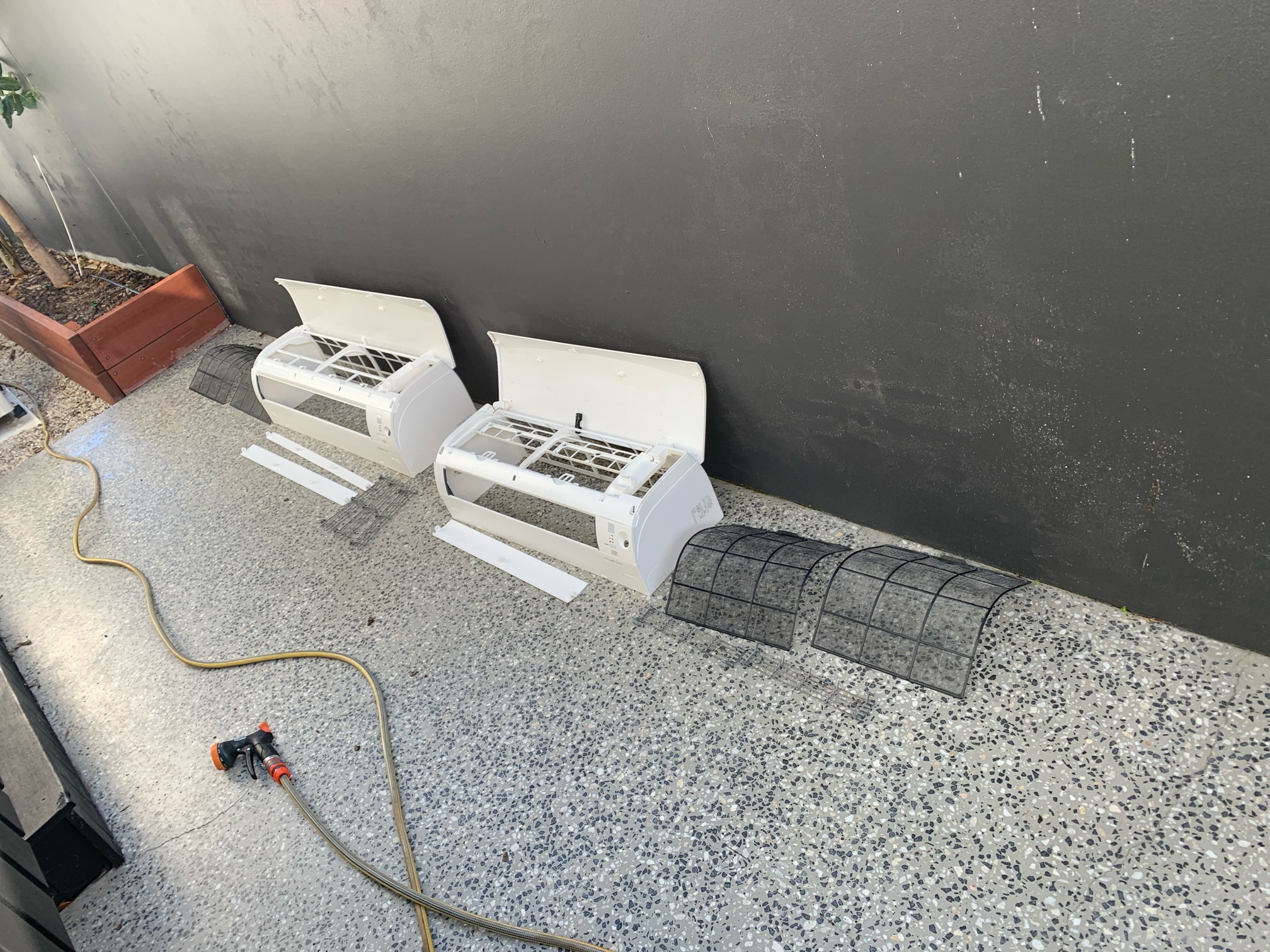 TemperCool technician carrying out split system servicing in a Gold Coast home